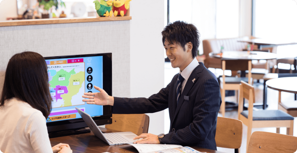 社員がお客様にモニターを使って説明してる写真